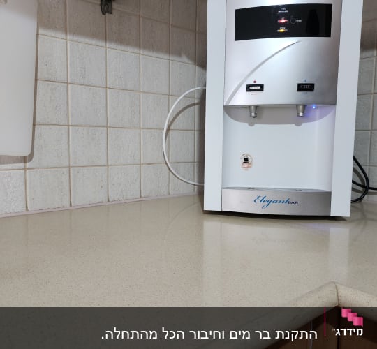 מכשיר מים על משטח מטבח עם אריחים